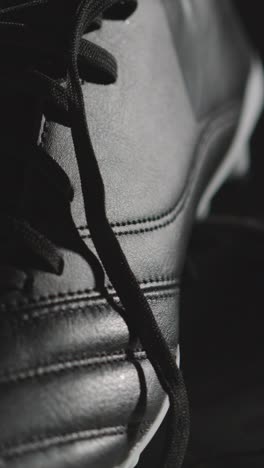 Vertical-Video-Studio-Still-Life-Shot-Of-Football-Soccer-Boots-Against-Black-Background